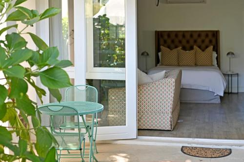 a porch with a bed and a table and a bed at Fransvliet Guest House in Franschhoek