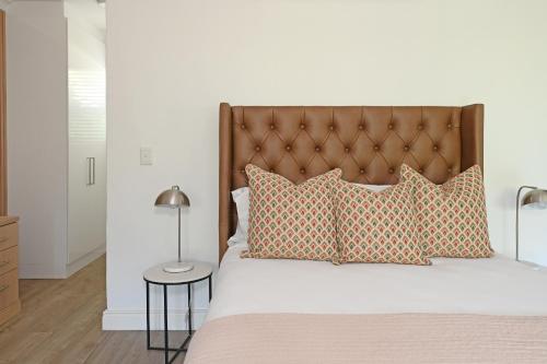 a bedroom with a large bed with orange pillows at Fransvliet Guest House in Franschhoek