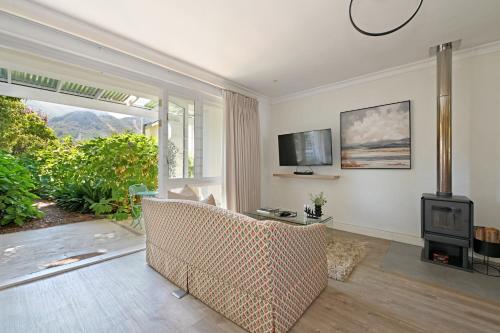 a living room with a couch and a television at Fransvliet Guest House in Franschhoek