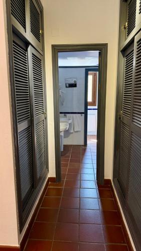 a hallway with a bathroom with a sink and a toilet at Cerro de Hijar in Tolox