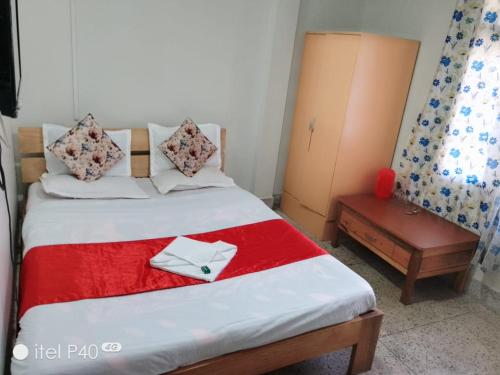 Un dormitorio con una cama con una manta roja y blanca. en Hotel Noryang, en Gangtok