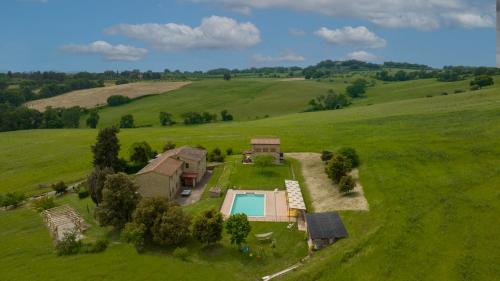 an aerial view of a house in a field with a pool at Agriturismo San Carlo in Pomarance