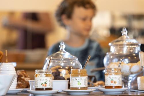 a boy sitting at a table with jars of honey at Agriturismo San Carlo in Pomarance