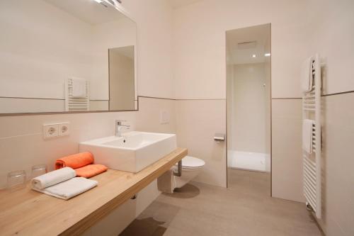 a white bathroom with a sink and a toilet at Garni Unterhaslerhof in Merano