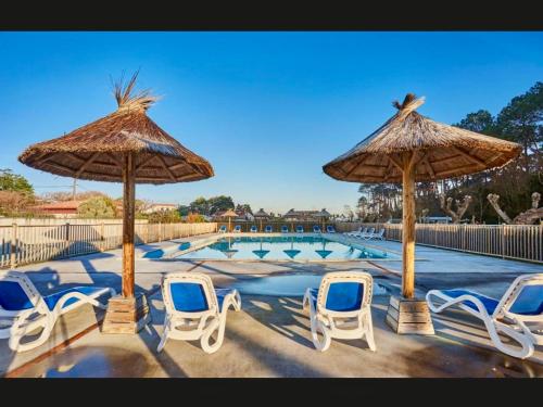 - un groupe de chaises longues et de parasols à côté de la piscine dans l'établissement Luzea, Domaine Iratzia, à Saint-Jean-de-Luz