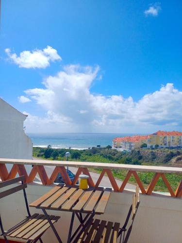 a balcony with a bench and a view of the ocean at Surf Yoga Ericeira Guest House in Ericeira