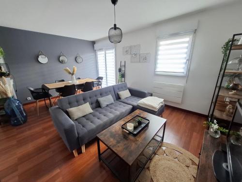 un salon avec un canapé et une table dans l'établissement Appartement Cosy Chartres-de-Bretagne, à Chartres-de-Bretagne