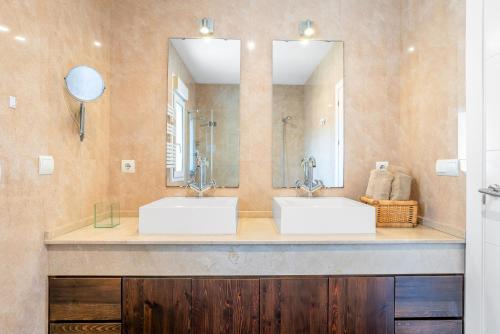 Un baño con dos lavabos y un espejo grande. en Villa El Cenador - Solo Familias, en Roche
