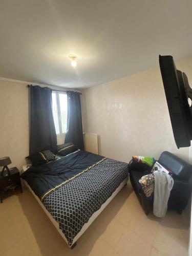 une chambre avec un lit et une télévision à écran plat dans l'établissement T3 Charmant et accessible, à Saint-Étienne-du-Rouvray