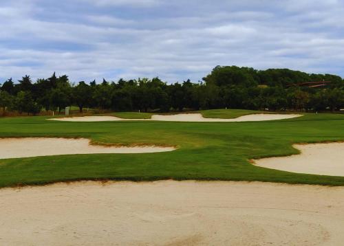 an aerial view of a golf course with sand ditches at Island Escape - Blue Residence in Conceição