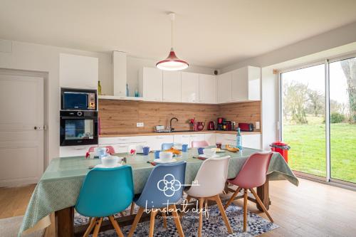 une cuisine avec une table et des chaises dans une cuisine dans l'établissement Maison cosy proche du Mans avec jardin et BBQ, à Parigné-lʼÉvêque