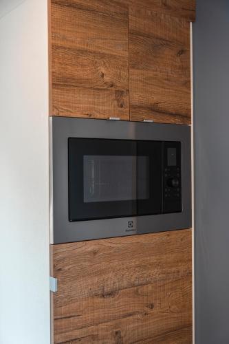 a microwave oven in a wooden wall at Domvs Glamp in Baveno