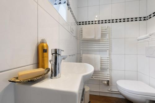 a white bathroom with a sink and a toilet at Apartment Altstadtflair in Husum