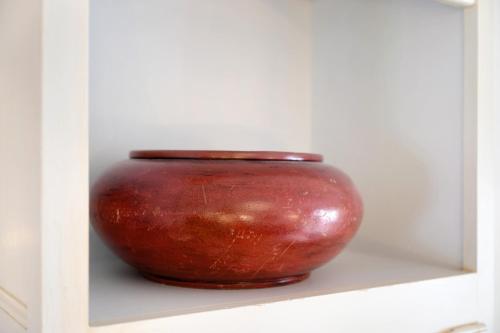 a red vase is sitting on a shelf at Apartment Altstadtflair in Husum