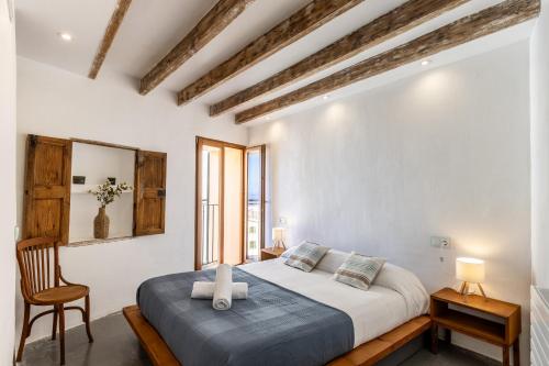 Un dormitorio con una cama grande y una silla. en Banyalbufar, en Banyalbufar
