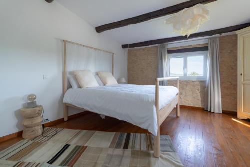 a bedroom with a bed and a window at L'Olivette d'Uzès YourHostHelper in Uzès