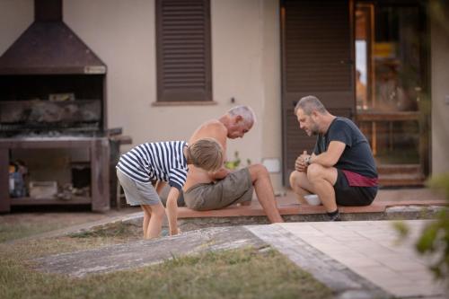 a group of people sitting on a curb in a yard at Agriturismo San Carlo in Pomarance