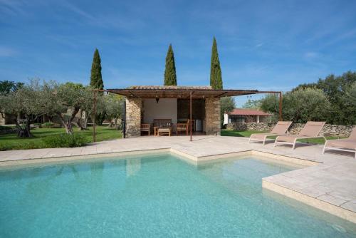 une piscine avec des chaises et un gazebo dans l'établissement L'Olivette d'Uzès YourHostHelper, à Uzès