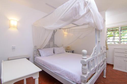 a bedroom with a white bed with a canopy at Luxury Ocean Apartment in Malindi
