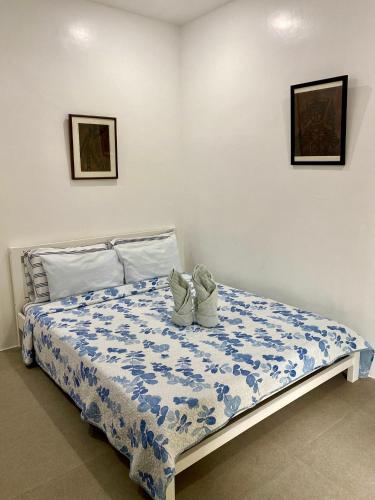 a bed with two shoes sitting on top of it at Villa Talisay Kaputian - Streetside Studio in Samal
