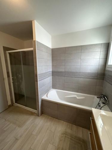 une salle de bain avec une baignoire et un lavabo dans l'établissement Villa piscine barbecue, à Codognan