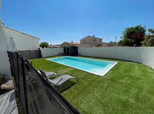 une arrière-cour avec piscine et pelouse dans l'établissement Villa piscine barbecue, à Codognan