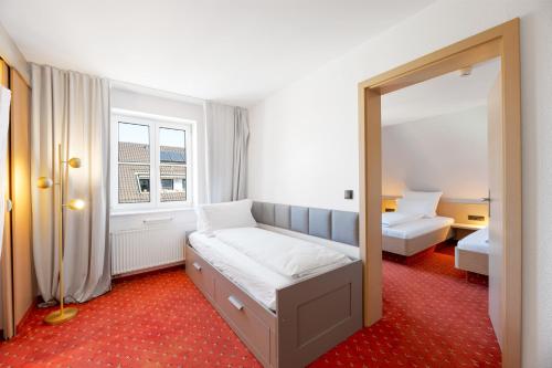 a bedroom with a bed and a mirror at Steiners Hotel Airport-Messe in Birkach in Stuttgart