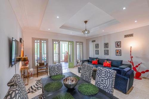 马拉喀什Luxury Apartment with Pool Large Terrace & Balconies in Hivernage Marrakech的客厅里有一张蓝色的沙发和椅子