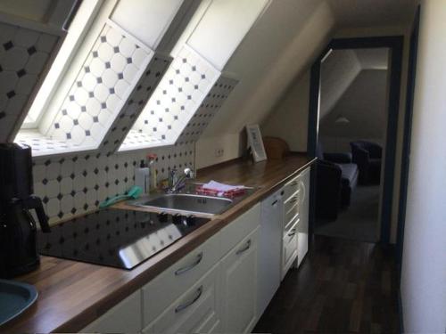a kitchen with a sink and a large window at Haus Seelord in Wenningstedt