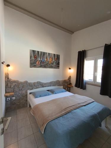 a bedroom with a large bed and a painting on the wall at Qća Krk Apartments in Dobrinj