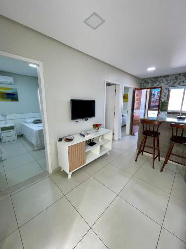 a living room with a television and a table at FLAT's TAVARES 102 in Garanhuns