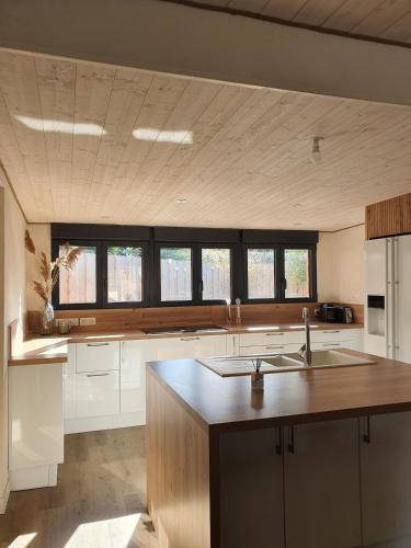 une grande cuisine avec des placards blancs et un évier dans l'établissement Villa Léonah Bassin d'Arcachon, à Gujan-Mestras