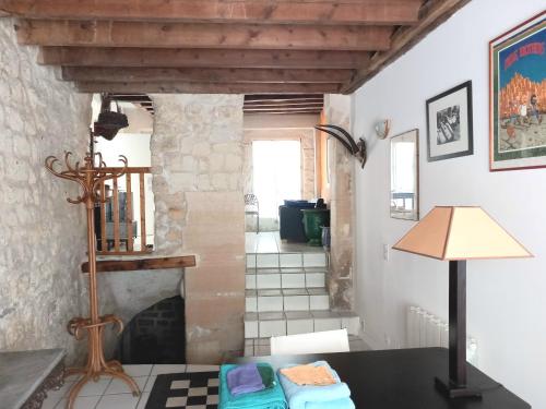 Cette chambre dispose d'une cheminée et d'une table avec une lampe. dans l'établissement Charmant loft dans maison ancienne, à Carrières-sur-Seine