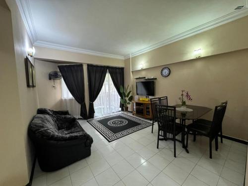 a living room with a couch and a dining room table at Golden Straits Villas Beach Resort - Nomad Homestay in Port Dickson