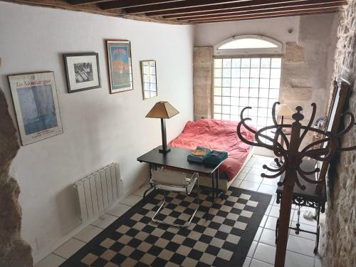 - une chambre avec un bureau, un lit et une fenêtre dans l'établissement Charmant loft dans maison ancienne, à Carrières-sur-Seine