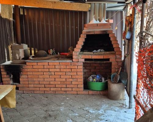 an outdoor brick pizza oven in a patio at Загородный дом Акжар in Aktobe