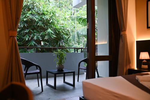 a room with a bed and a window with a plant at Hiriketiya Beach Resort in Hiriketiya
