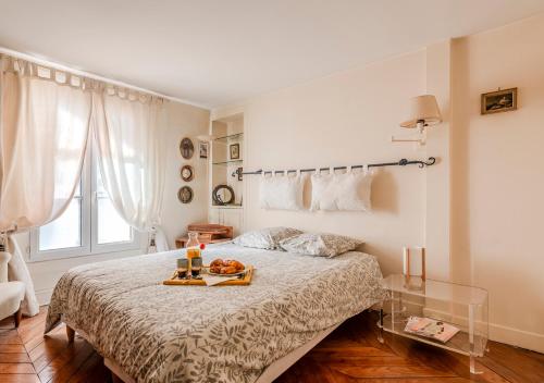 - une chambre avec un lit et un plateau de nourriture dans l'établissement La Pause Parisienne, au pied du métro, à Paris