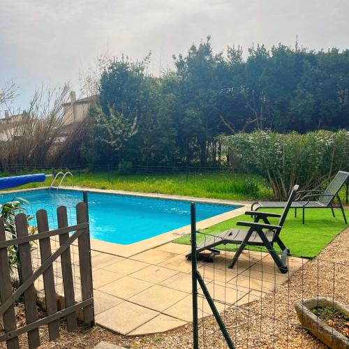 - une piscine avec 2 chaises et une table à côté d'une clôture dans l'établissement Maisonnée dans mas provençal typique, à Saint-Rémy-de-Provence
