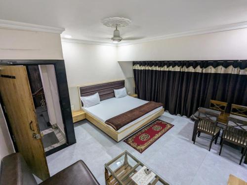 a bedroom with a bed and a table and a chair at Hotel Shivneri in Bilāspur