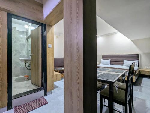 a room with a bed and a table and a sink at Hotel Shivneri in Bilāspur