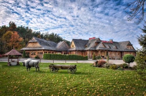 a horse drawn carriage in front of a large house at Jakubowa Izba in Niwa Babicka