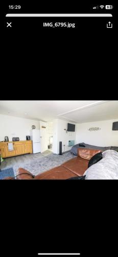 two pictures of a room with a bed and a living hype at Sunnyside guest house in Latchingdon and Snoreham