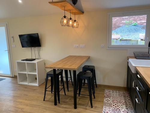 - une cuisine avec une table et des tabourets en bois dans l'établissement La Loubière - le gîte au cœur de la nature, à Combret