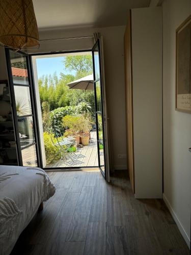 a bedroom with a door open to a patio at Comme un petit coin de paradis à Trégastel in Trégastel