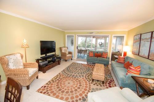 a living room with a blue couch and a tv at Beach Club Villa 39 by Wild Dunes, Oceanfront in Isle of Palms