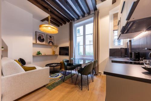 Il comprend une cuisine et un salon avec une table. dans l'établissement Parisian Luxury Living rue Dauphine Saint-Germain-des-Prés, à Paris