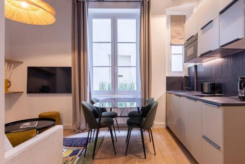 une cuisine avec une table et des chaises dans une pièce dans l'établissement Parisian Luxury Living rue Dauphine Saint-Germain-des-Prés, à Paris