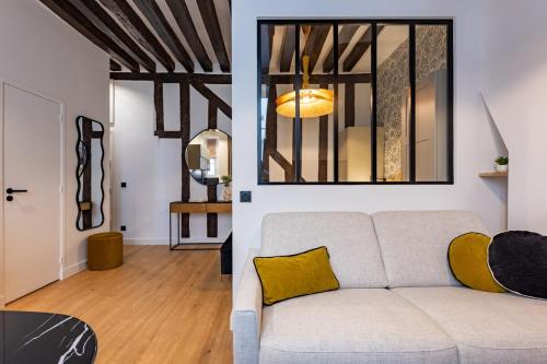 - un salon avec un canapé blanc et un oreiller jaune dans l'établissement Parisian Luxury Living rue Dauphine Saint-Germain-des-Prés, à Paris