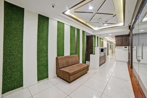 a chair in a hallway with green walls at Townhouse Tulip in Vadodara